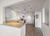 Thumbnail 8 of 208 - A modern kitchen with white cabinets and a wooden floor.