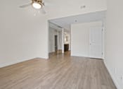 Thumbnail 22 of 208 - A room with a ceiling fan and light fixture, and a door leading to another room.