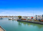 Thumbnail 36 of 208 - A marina with boats docked and a clear blue sky.