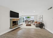 Thumbnail 7 of 228 - A modern living room with a fireplace and a flat screen TV mounted on the wall.