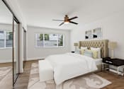 Thumbnail 11 of 228 - A bedroom with a large bed and a ceiling fan.