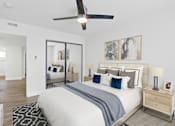 Thumbnail 14 of 228 - A bedroom with a large bed, a ceiling fan, and a mirror on the wall.