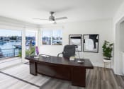 Thumbnail 33 of 135 - a home office with a large wooden desk and a sliding glass door that leads to a deck
