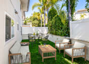 Thumbnail 36 of 135 - a patio with a wooden table and chairs and a white fence