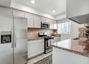 Thumbnail 1 of 25 - A modern kitchen with a granite countertop and stainless steel appliances.