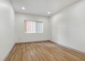 Thumbnail 18 of 25 - A room with wooden flooring and a window with blinds.