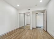 Thumbnail 20 of 25 - A room with a white wall and a wooden floor.