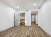 Thumbnail 23 of 25 - A room with a white door and a white wall.