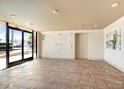 Thumbnail 5 of 25 - A room with tile flooring and a view of the street through the windows.