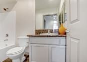 Thumbnail 15 of 25 - A white toilet sits next to a bathtub in a bathroom.