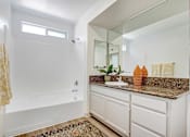 Thumbnail 13 of 25 - A bathroom with a white tub and sink.