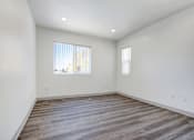 Thumbnail 21 of 25 - A room with a large window and wooden flooring.