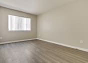 Thumbnail 17 of 25 - A room with a window and wooden flooring.