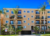 Thumbnail 15 of 15 - A building with balconies and palm trees in front.