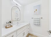 Thumbnail 13 of 20 - A bathroom with a white counter top and a mirror.