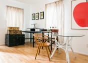 Thumbnail 1 of 10 - a dining room with a glass table and chairs