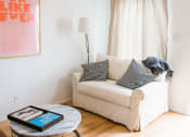 Thumbnail 2 of 10 - a living room with a couch and a table with a tablet on it