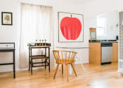 Thumbnail 4 of 10 - a dining room with a table and chairs and a painting of an apple