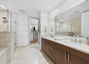Thumbnail 3 of 40 - A bathroom with a walk in shower and double sinks.