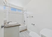 Thumbnail 10 of 64 - A white bathroom with a sink, toilet, and bathtub.