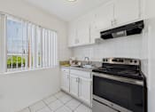 Thumbnail 2 of 64 - A kitchen with white cabinets and a black stove top oven.