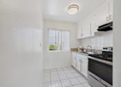 Thumbnail 3 of 64 - A kitchen with white cabinets and a black stove top oven.