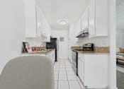 Thumbnail 6 of 64 - A kitchen with white cabinets and a granite countertop.
