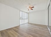 Thumbnail 16 of 74 - A room with a ceiling fan and wooden flooring.