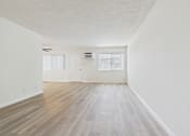 Thumbnail 14 of 74 - A room with wooden flooring and white walls.