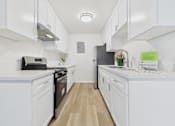 Thumbnail 10 of 74 - A kitchen with white cabinets and appliances.
