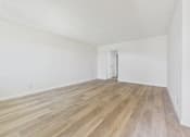 Thumbnail 15 of 74 - A room with a wooden floor and a door.