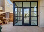 Thumbnail 22 of 59 - a patio with glass doors and a table and chairs