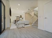 Thumbnail 16 of 59 - a living room with a couch and a table and a staircase