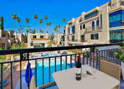Thumbnail 3 of 59 - a balcony with a pool and a table with a bottle of wine