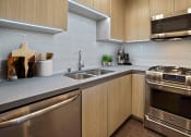 Thumbnail 1 of 59 - a modern kitchen with stainless steel appliances and wooden cabinets