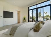 Thumbnail 19 of 59 - a bedroom with a large bed and a tv on the wall