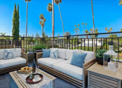Thumbnail 24 of 59 - a patio with couches and tables on a balcony with palm trees