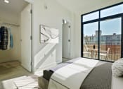 Thumbnail 18 of 59 - a bedroom with a bed and a door to a balcony