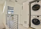 Thumbnail 17 of 59 - a washer and dryer in a laundry room with a door