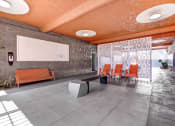 Thumbnail 5 of 27 - a lounge area with orange chairs and a whiteboard on the wall