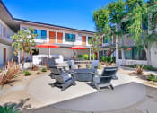 Thumbnail 3 of 27 - a patio with a table and chairs in front of a building