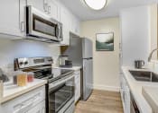 Thumbnail 1 of 24 - a kitchen with stainless steel appliances and white cabinets