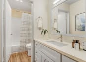 Thumbnail 16 of 24 - a bathroom with a sink and a mirror and a shower