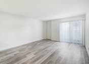 Thumbnail 22 of 24 - the living room of an apartment with wood flooring and a large window