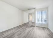 Thumbnail 23 of 24 - an empty living room with a mirror and a sliding glass door