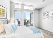 Thumbnail 4 of 39 - a bedroom with a bed and sliding glass doors to a balcony