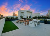 Thumbnail 31 of 39 - a patio with a grill and a city skyline in the background
