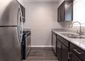 Thumbnail 50 of 63 - Kitchen with Stainless Steel Appliances in the Two Bedroom Townhome at Woodbridge Apartments Bloomington