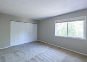 Thumbnail 46 of 63 - Primary Bedroom with a Closet and Large Windows in the Two Bedroom Townhome at Woodbridge Apartments Bloomington