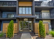 Thumbnail 36 of 39 - Exterior of an apartment building at Woods of Fairfax, featuring balconies and well-maintained landscaping.